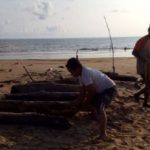 MENUMPUK DAN TERSERAK: Salah seorang warga Desa Legung sedang mengambil sampah kayu di Pantai Lombang Sumenep dibantu seorang pengunjung.