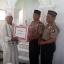 GIAT JUMRAH: Kapolres Bangkalan, AKBP Anisullah M Ridha memberikan karpet dan sajadah kepada H. Zahri tokoh agama Desa Banyoneng Daja, Kecamatan Geger, Bangkalan saat Giat JUMRAH. (Foto/Hasin)
