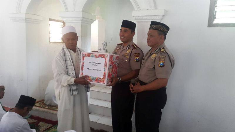 GIAT JUMRAH: Kapolres Bangkalan, AKBP Anisullah M Ridha memberikan karpet dan sajadah kepada H. Zahri tokoh agama Desa Banyoneng Daja, Kecamatan Geger, Bangkalan saat Giat JUMRAH. (Foto/Hasin)