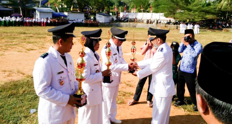KOMPETITIF: Camat Syahroni menyerahkan Piala dan Sertifikat sebagai penghargaan bagi tiga desa peraih juara lomba antar desa se-Kecamatan Batang-Batang, usai detik-detik upacara HUT RI ke-71, disaksikan ratusan peserta upacara. (Foto/Dok. ASY)